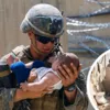 Афганцы, потерявшие надежду улететь, передают солдатам НАТО своих детей / Фото Reuters
