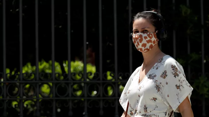 Девушка в маске идет по улице. Фото: REUTERS/Albert Gea