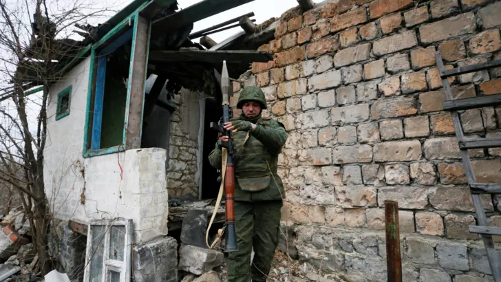 Фото Alexander Ermochenko/Reuters
Боевик т.н. "ЛНР" на территории разрушенного дома