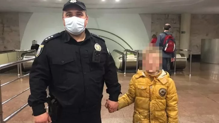 Полицейский с найденным в метро мальчиком