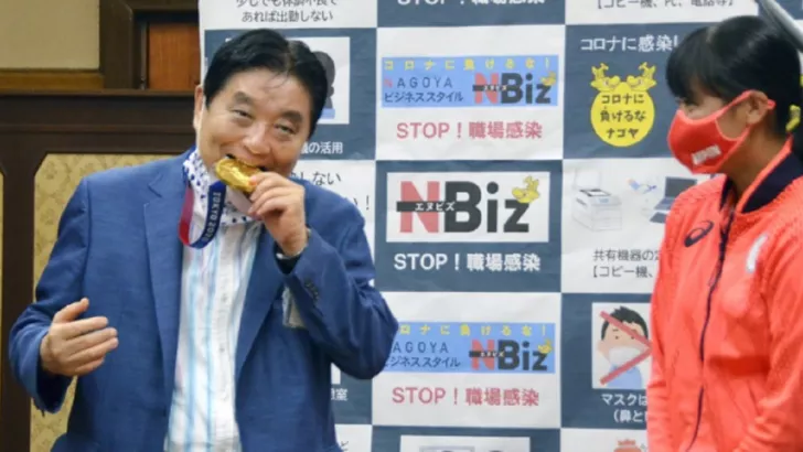 Мэр укусил медаль чемпионки. Фото Kyodo