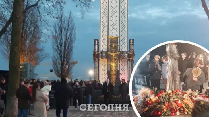 Люди воруют яблоки, принесенные к мемориалу Голодомора в Киеве