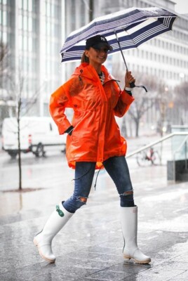 Стильное сочетание белых сапог с оранжевым дождевиком | Фото: Pinterest