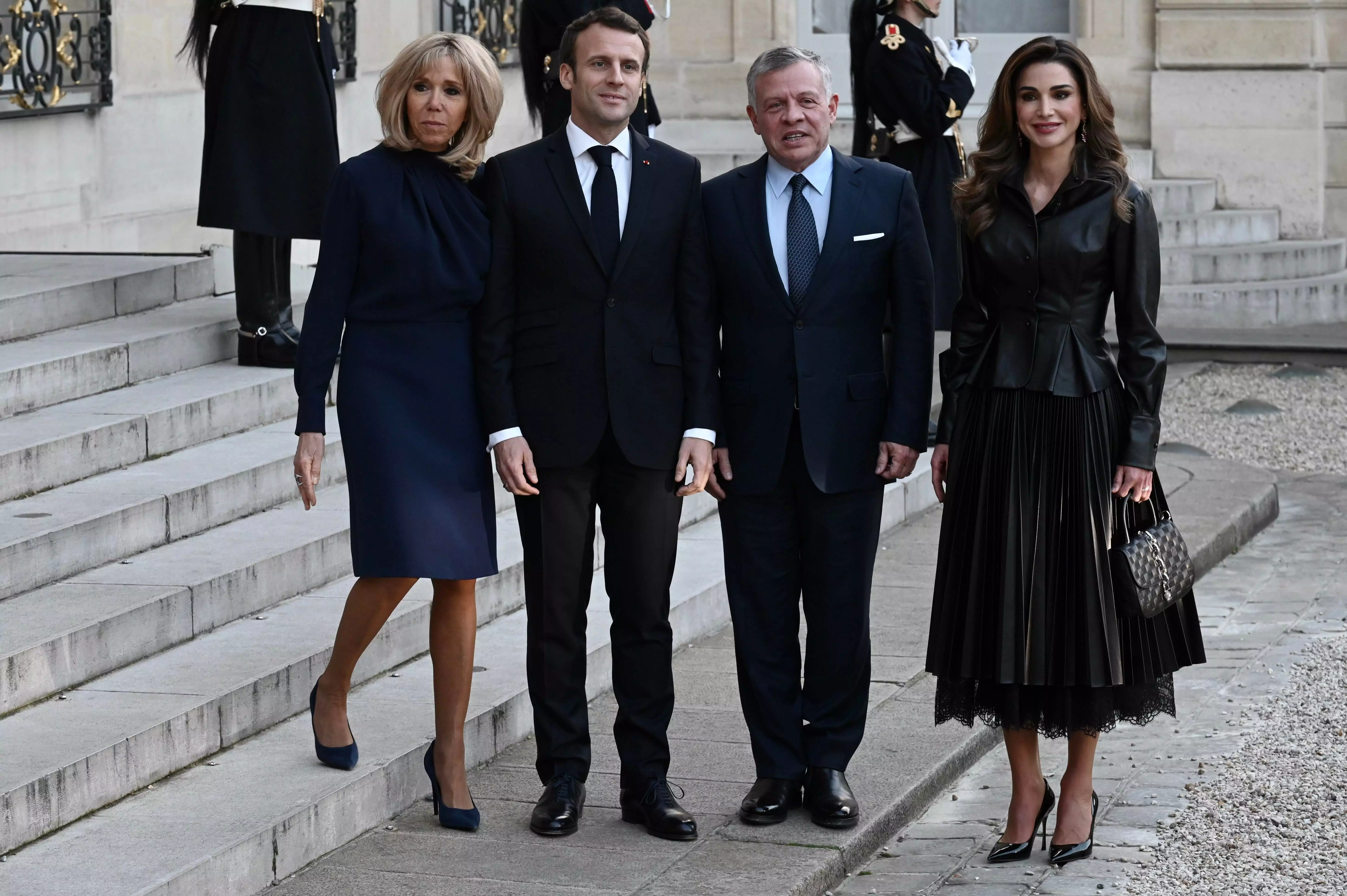 Королева Йорданії Ранія з президентським подружжям Франції в чорному піджаку і спідниці-плісе з еко-шкіри