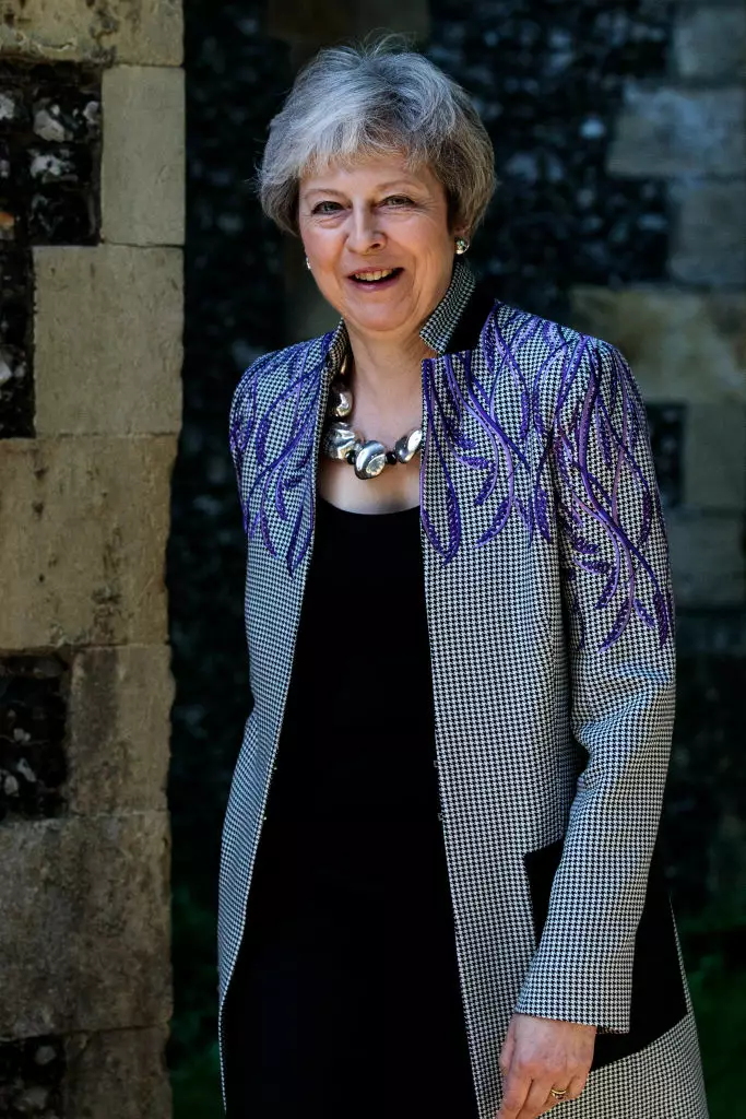 Тереза Мэй в клетчатом пальто с лиловой вышивкой на плечах