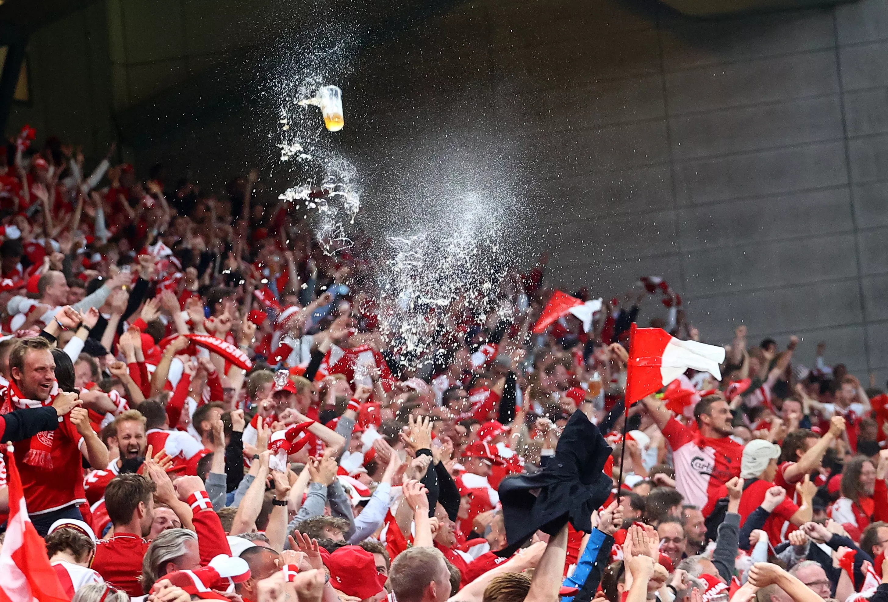 Болельщики сборной Дании бросают стаканчики с пивом на стадионе Евро-2020