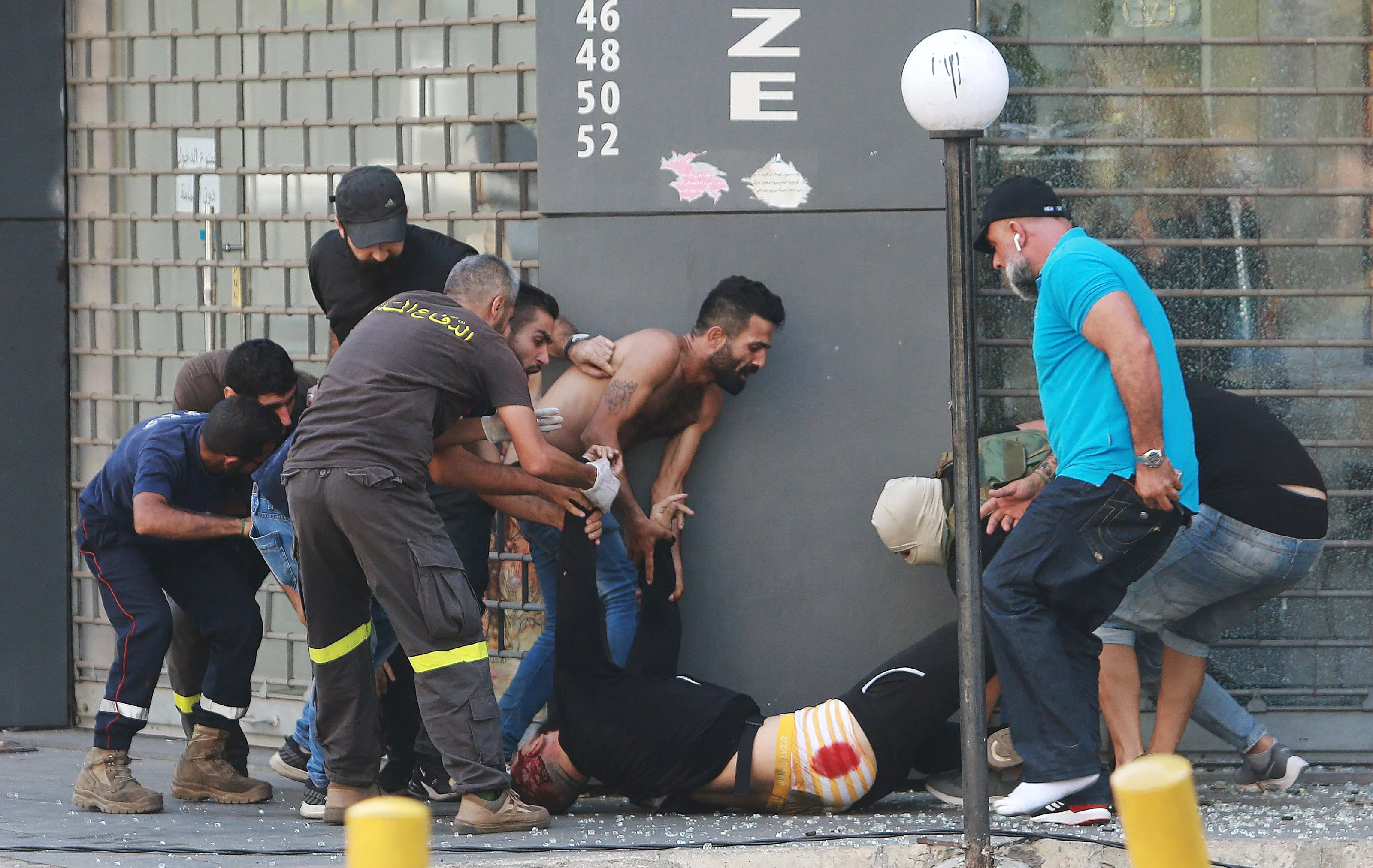 Люди забирают мужчину, который был застрелен во время перестрелки в Бейруте/Фото: REUTERS/Aziz Taher