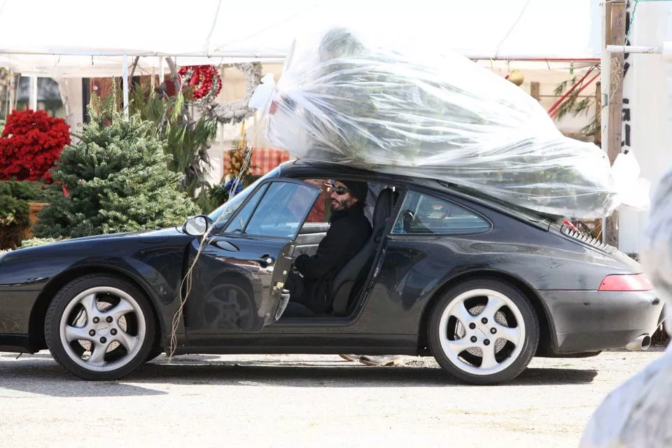 Киану Ривз перевозит елку на спорткаре.