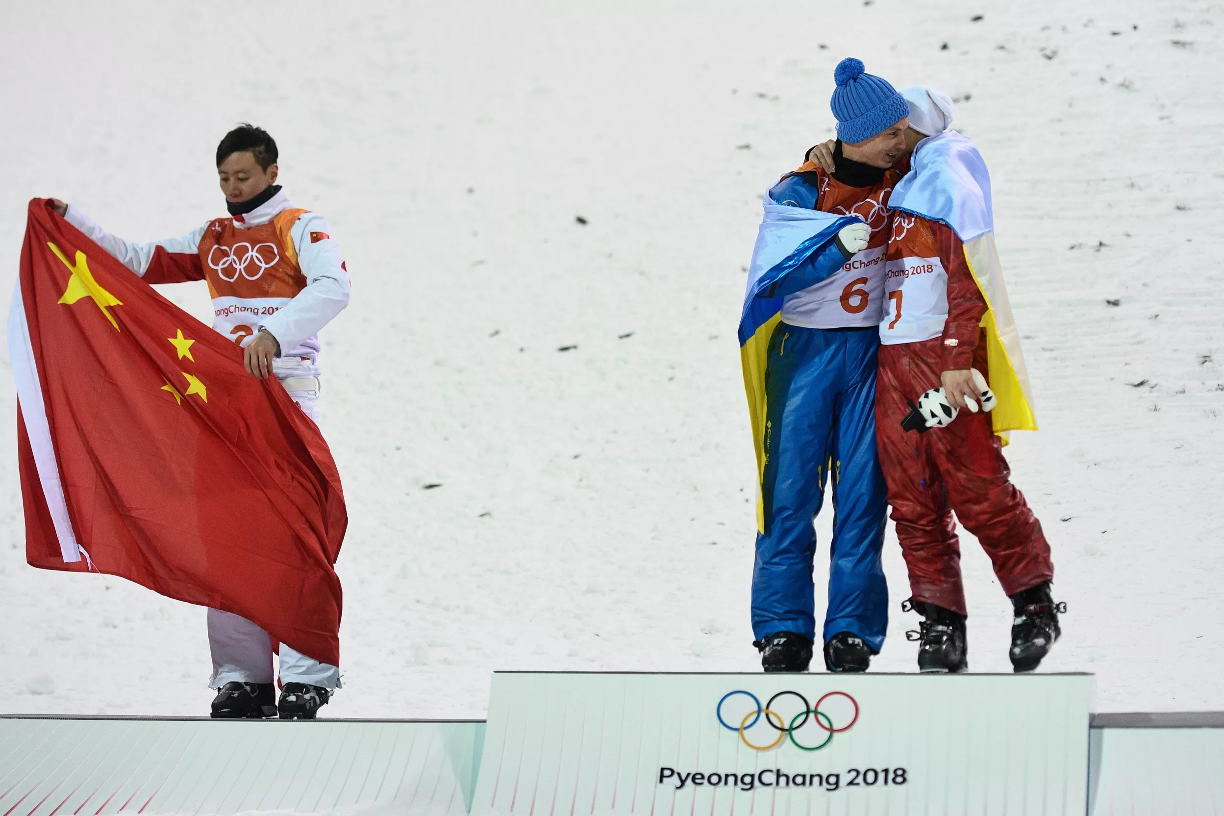 Олімпіада-2018: Абраменко обіймає росіянина Бурова, закутавшись в український прапор. Фото: Getty Images