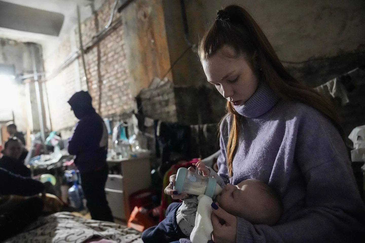 Молодая мама кормит ребенка в бомбоубежище в Мариуполе