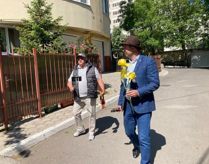 К дому Додона, где проходили обыски, бывший профессор Аграрного университета, а ныне – таксист принес  шампанское, а его друг – желтые цветы (к расставанию)