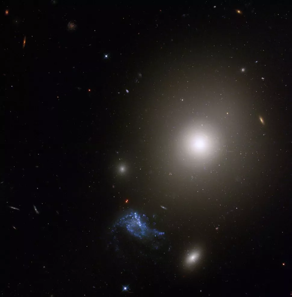 Ліворуч світиться блакитним кольором у нижній частині зображення карликова галактика, а вище – еліптична галактика NGC 541