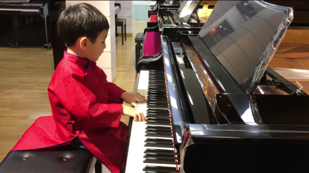 Мальчик мастерски играет на пианино. Кадр из видео