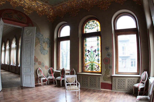 Женский зал. Потолок оформлен шикарными цветами-символами, а окна — яркими витражами