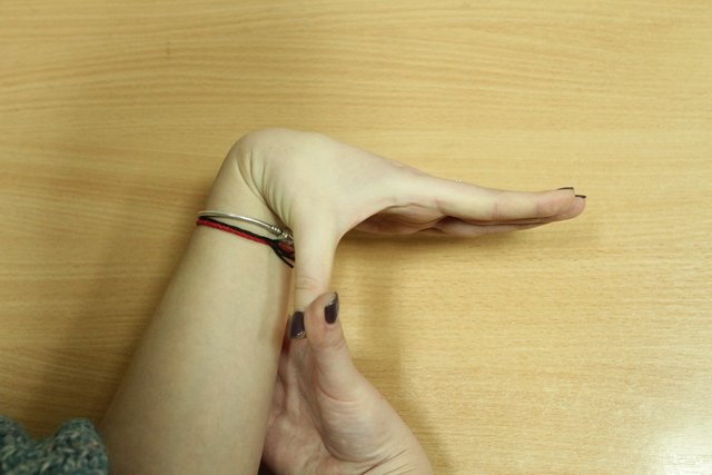 Пружинящими движениями большим пальцем правой руки тяните большой палец левой кисти к левому предплечью. Аналогично сделайте упражнение на другой руке.
