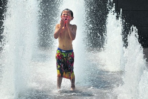 Вашингтон. В столице США жители спасаются от жары в фонтанах. Фото AFP