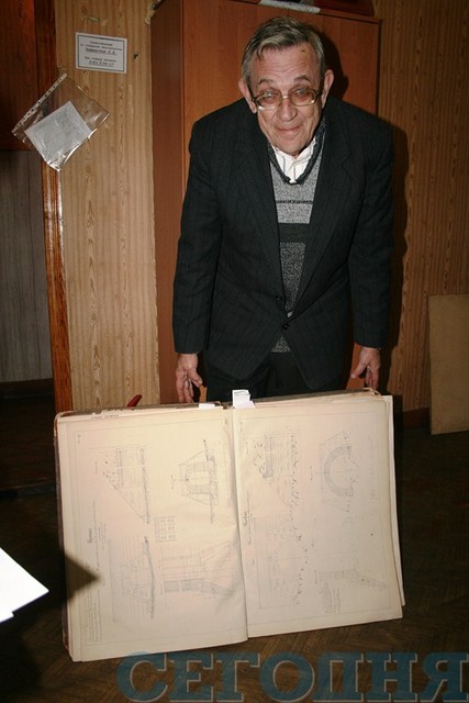 Хранитель музея Юрий Лынюк держит книгу с чертежами. Фото: С. Жукова