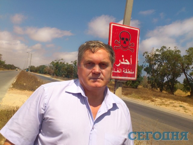 Селиванов (на фото) говорит, что этот снимок хорошо демонстрирует происходящее сейчас в Ливии. Надпись на табличке в переводе значит 