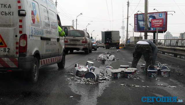 Водитель собирает кильку на Шулявском мосту в Киеве | Фото: Александр Яремчук