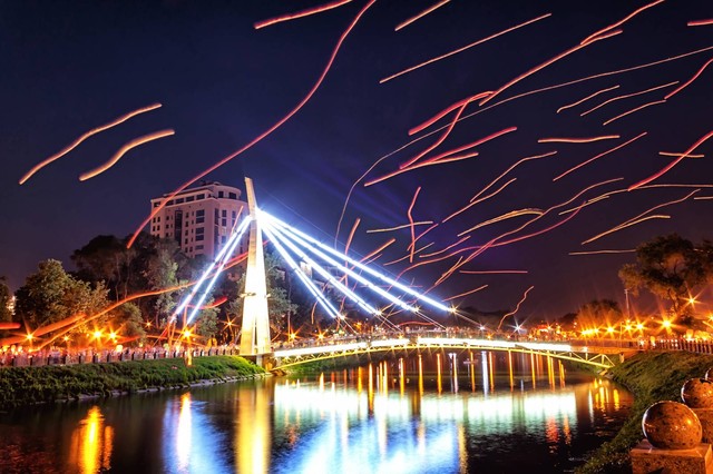 Набережная в огнях. Новый мост, снятый на большой выдержке, выглядит будто в падающих метеоритах. Фото: Р.Медведев