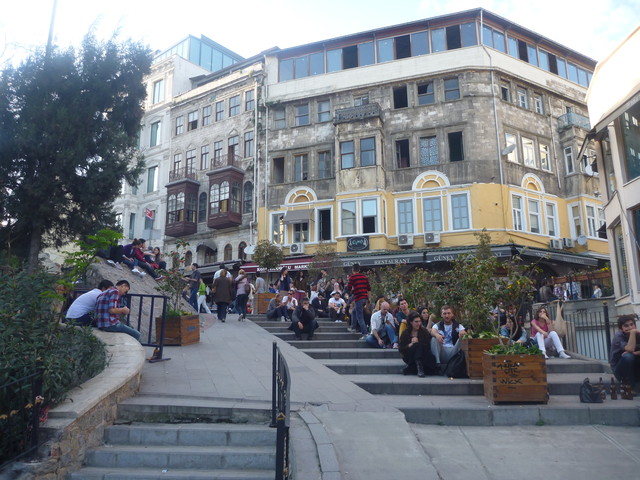 возле Галатской башни местные жители и туристы сидят прямо на ступеньках