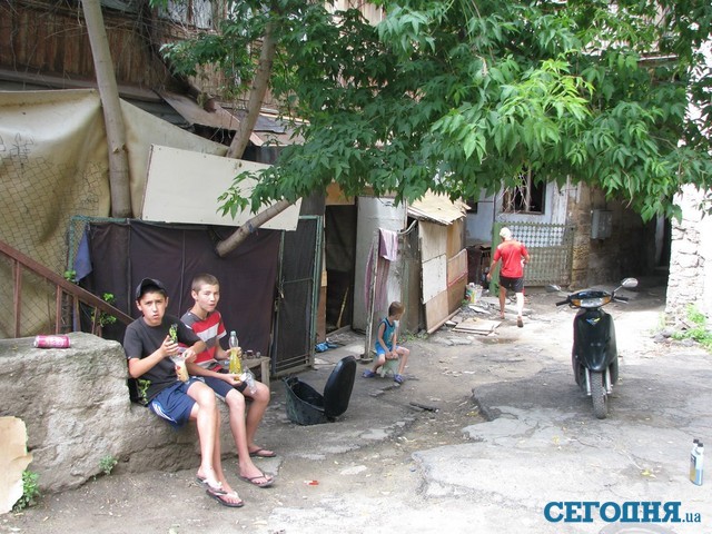Под аварийным домом. Десять человек живут в картонных шалашах во дворе. Еду готовят на костре. Фото: А. Жуков