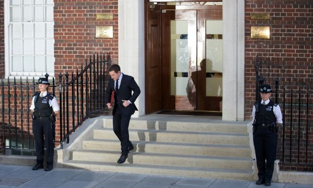 Пресс-секретарь королевского дома Эд Перкинс выходит из больницы с документом о появлении на свет наследника. Фото AFP