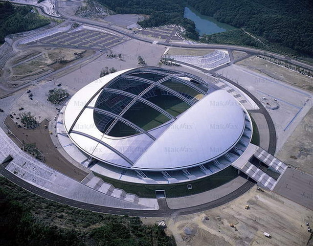 7. Стадион Oita <br />
Стадион Oita — многоцелевой стадион в городе Оита на острове Кюсю в Японии. Стадион был построен по проекту архитектора Кисё Курокава, который осуществила компания KT Group, Takenaka Corporation. Стадион Оита открылся в мае 2001 года и первоначально вмещал 43 000 зрителей. Он принял у себя 3 матча в рамках Чемпионата мира по футболу 2002 года. <br />
Стадион обладает выдвижной куполообразной крышей. Площадь сооружения: 51 830 м². Общая площадь: 92 882 м².<br />
