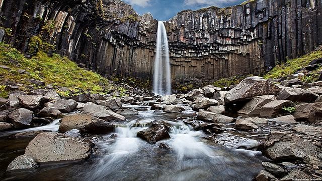 7. Скафтафетль<br />
Скафтафетль — национальный парк на юге Исландии. Он основан 15 сентября 1967 года. Сегодня его площадь составляет около 4807 км², это второй по величине национальный парк в Исландии. На его территории находятся долина Морсардалур, гора Кристинартиндар, ледник Скафтафетльсьокуль (отрог большого ледника Ватнайёкюдль) и известный вулкан Лаки. <br />
Ландшафт аналогичен ландшафту Альп, однако он формировался тысячелетиями под влиянием огня (извержения вулкана Эрайвайёкюдль) и воды (ледники Скейдарайокудль и Скафтафетльсьокуль, реки Скейдара, Морса и Скафтафеллса). Вулканические извержения под ледниковой шапкой вызывали неоднократные ледниковые стоки, которые значительно подняли уровень воды в реке Скейдара. В парке имеется березовый лес,где обитает множество видов птиц. Водопад Свартифосс (Черный водопад) спадает с уступа высотой около 12 м. Водопад получил своё название из-за чёрных базальтовых колонн позади водопада.<br />

