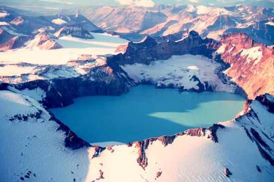 7. Кратерное озеро вулкана Катмай<br />
Катмай — действующий вулкан, или слоистый вулкан, на юге полуострова Аляска, расположенный на территории национального парка Катмай. Вулкан, достигающий 10 км в диаметре, имеет центральную котловину, заполненную озером, размерами 4.5 на 3 км, которая образовалась при извержении вулкана Новарупта в 1912 году. Максимальная высота Катмая, на которой и лежит котловина — 2047 метров над уровнем моря. В 1975 году водная поверхность кратерного озера находилась на высоте около 1286 метров, а расчетная высота, на которой находилось дно котловина, составила 1040 метров. 1919 году геологи отметили почти полное заполнение котловины озером, но к 1923 году озеро исчезло, и его место заняли многочисленные грязевые котлы, грязевые гейзеры и фумаролы. К настоящему времени озеро восстановилось и сейчас его глубина достигает примерно 240 метров. Кроме того, на склонах вулкана образуются небольшие ледники.<br />
