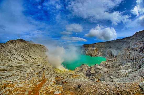 10. Озеро Kawah Ijen<br />
Озеро под названием Kawah Ijen в Индонезии расположено в кратере вулкана. Фактически, это озеро, наполненное серной кислотой. Вулкан находится на высоте около 2400 метров над уровнем море, диаметр его кратера – 175 метров, а глубина – 212 метров. В его жерле расположено, наверное, самое странное и пугающее озеро прекрасного яблочно -изумрудного цвета. Всего же в озере по приблизительным подсчетам содержится более 200 тонн алюминия. На поверхности озера температура колеблется в районе 60 градусов, а на его дне достигает и все 200 градусов.<br />
