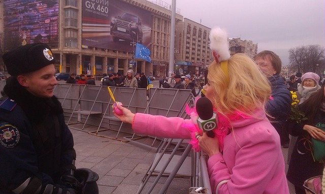 Блондинка в розовом предлагает милиционеру мыльные пузыри. Фото: Олег Апостолов