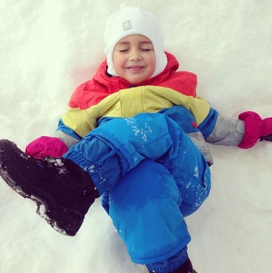 Маленький Саша с удовольствием валяется в снегу