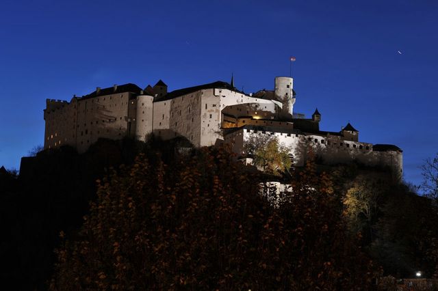 Хоэнзальцбург<br />
Хоэнзальцбург— одна из крупнейших средневековых крепостей Европы. Расположена на вершине горы Фестунг рядом с Зальцбургом, Австрия, на высоте 120 метров. Крепость Зальцбурга — одна из крупнейших из целиком сохранившихся средневековых крепостей Европы. Площадь крепости — 30 тыс. м² (до 250 м в длину и 150 м в ширину). Добраться до крепости можно либо на фуникулере из Старого города, либо пешком. В 1077 году архиепископом Зальцбурга Гебхардом I был построен замок в романском стиле, от которого сегодня сохранился лишь фундамент. Позднее замок несколько раз перестраивался и укреплялся, постепенно превращаясь в мощную укрепленную крепость. Свой нынешний вид Хоэнзальцбург в общих чертах приобрел в XVI веке. Около 1500 года в замке был построен первый в мире фуникулер Райсцуг, предназначенный для доставки товаров. Хоэнзальцбург лишь один раз подвергался осаде, когда группа шахтеров, крестьян и горожан в 1525 году пыталась свергнуть князя Маттеуса Ланга. В XIX веке замок использовался в качестве казармы, склада и тюрьмы, прежде чем вновь стала военным форпостом в 1861 году. Сегодня замок является одной из основных туристических достопримечательностей Зальцбурга. Из центра города к Хоэнзальцбургу ведет канатная дорога. В крепостном музее представлены экспонаты истории города, крепости, военной истории Австрии, большая коллекция оружия разных эпох. Хранится также посмертная маска фельдмаршала Радецкого.<br />
