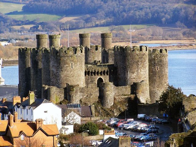 Замок Конуи<br />
Замок Конуи  — средневековый замок, находится в городе-графстве Конуи в Уэльсе. Замок был построен в 1283—1289 годах по приказанию Эдуарда I Английского. В течение четырех лет, работая с марта по октябрь, 1500 человек возвели крепость и стены. Замок Конуи окружен каменной стеной с 8 круглыми башнями и бойницами. Башни замка многоэтажные, их высота около 20 м. Внутренний двор разделен на 2 части огромной поперечной стеной. В одной из частей находился зал для приемов. Замок долгое время был заброшен и медленно разрушался. Замок разделен на два дворика – внутренний и внешний, – причем каждый из них окружен толстыми стенами с 4 башнями по углам. Башни многоэтажные, их высота около 70 футов (20 м), диаметр -30 футов (около 10 м), толщина стен – 15 футов (примерно 4 м).  До наших дней дошли лишь стены замка, но и в таком виде они выглядят достаточно внушительно. С высоты стен замка Конуи открывается прекрасный вид на городок Конуи, одноименный залив и зеленые холмы Уэльса.<br />
