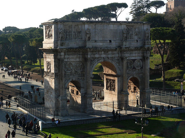 Триумфальная арка Константина<br />
Триумфальная арка Константина — арка, расположенная в Риме между Колизеем и Палатином на древней Via Triumphalis. Построена она в 315 году и посвящена победе Константина над Максенцием в битве у Мильвийского моста 28 октября 312 года. Арка является позднейшей из сохранившихся римских триумфальных арок, использует элементы декора, снятые с более древних монументов. Кроме того, это единственная в Риме арка, построенная в честь победы не над внешним врагом, а в гражданской войне. Арка имеет высоту 21 м, ширину 25,7 м и глубину 7,4 м. Центральный пролет 11,5 м высотой и 6,5 шириной, боковые: по 7,4 м и 3,4 м. Основная часть монумента выполнена из мраморных блоков, аттик кирпичный, облицованный мрамором.<br />
