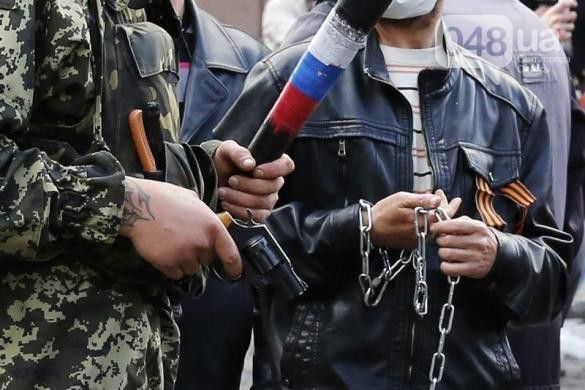 Мужчины с георгиевскими лентами и российской символикой держат пистолеты Фото: 048.ua