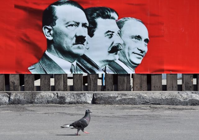 Україна, Київ. На головній площі столиці з'явилися плакати із зображенням Адольфа Гітлера, Йосипа Сталіна і президента РФ Володимира Путіна. Фото: AFP