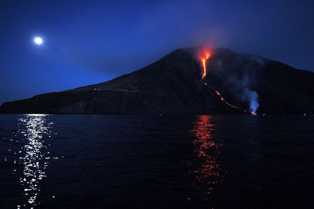 В Італії на острові Сицилія знову прокинувся знаменитий вулкан Етна. Над вулканом піднімається стовп диму і попелу, а потік лави повільно рухається в напрямку безлюдної Бичачої долини. У минулому році Етна – найбільший діючий вулкан Європи – був внесений до списку Всесвітньої спадщини ЮНЕСКО. Фото: AFP
