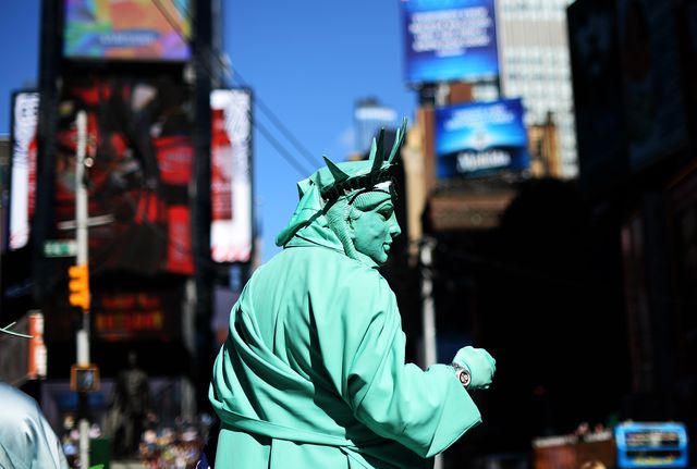 В Нью-Йорке мужчина, переодетый в костюм Статуи свободы, просит милостыню у туристов. Таким образом он пытается привлечь внимание к безработице. Фото: AFP