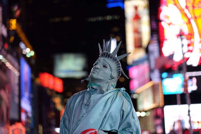 Чоловік в образі Статуї свободи дивиться на 24 млн піксельний рекламний дисплей на площі Таймс Сквер в Нью-Йорку. Екран становить в 2,320 кв. метрів в величину і володіє найбільшим розширенням в світі серед собі подібних "гігантів". Фото: AFP