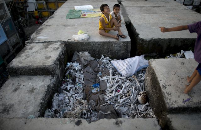 31 жовтня, 2014. Мало хто має нормальне житло у філіппінській столиці Манілі. Маніла – це місто з населенням близько 12 мільйонів осіб. Він вважається одинадцятим за величиною мегаполісом у світі і п'яте за чисельністю населення. Крім того, Маніла має одну з найбільших густин населення у світі. Переважна більшість жителів міста бідні. До 40% населення Маніли живе за межею бідності, вони часто не можуть дозволити собі нічого кращого, ніж життя в міських нетрях. Тисячі бідних жителів не в змозі придбати собі навіть найгірше житло і змушені шукати альтернативу. А деякі жителі цього міста влаштували собі житло прямо на міському кладовищі. Фото: AFP