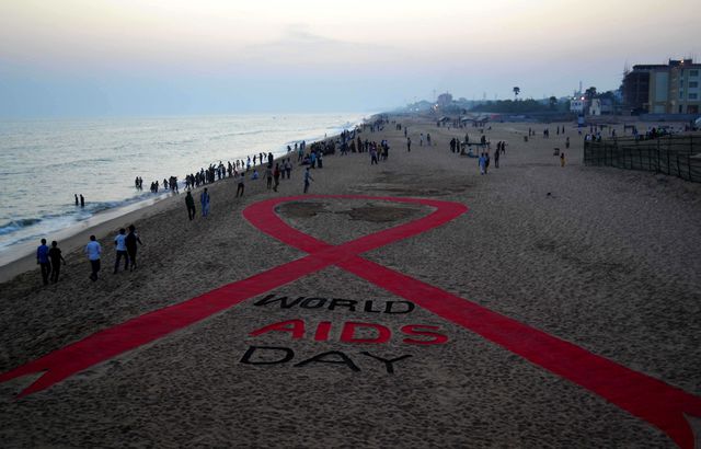 В Индии символично отметили День борьбы против СПИДа. Индия стоит на третьем месте по числу ВИЧ-инфицированных в мире. Более половины смертей от СПИДа в Азиатско-Тихоокеанском регионе приходится именно на Индию. К примеру, в 2012 году от СПИДа здесь скончались 140 тысяч человек. Согласно данным ВОЗ, только 50% возможных пациентов в том году получили помощь по программе бесплатных препаратов, которая действует в Индии с 2004 года. Фото: AFP