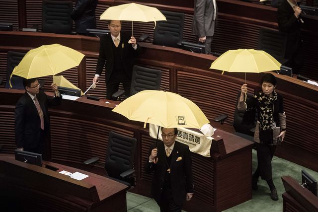 Продемократичні члени Законодавчої ради Гонконгу бойкотували щорічне звернення глави адміністрації Лян Чженьіна. Вони закликали його піти у відставку. Перед входом в будівлю Ляна зустріли близько 70 опозиційних парламентаріїв і протестувальників. Вони тримали банери і парасольки з вимогами повної демократії. Фото: AFP