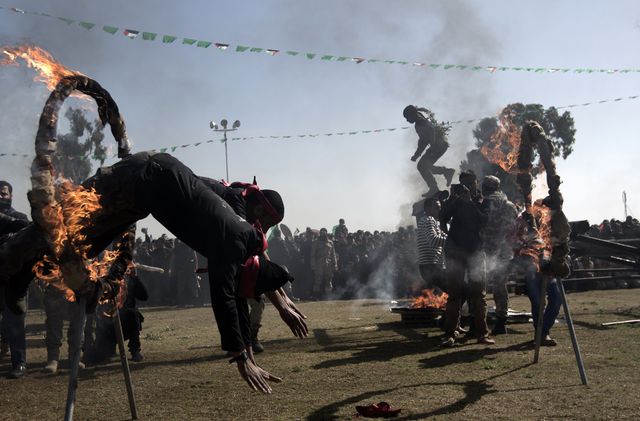 Палестинская молодежь прыгает через огненные кольца во время церемонии вручения дипломов в рамках посвящения в движение ХАМАС. Фото: AFP