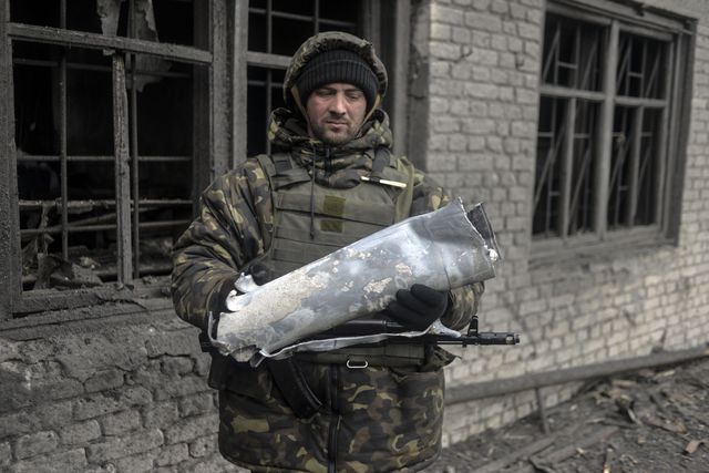 Украинский военный держит фрагмент ракеты "Града", которой боевики обстреливали город. Фото: AFP
