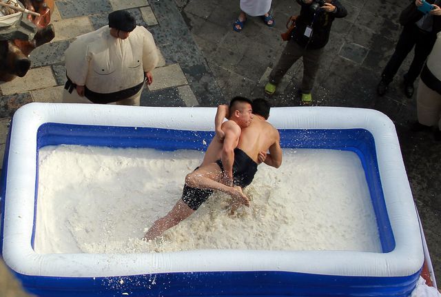 В китайской провинции Гуандун прошли соревнования. Участники борются в надувном бассейне, заполненном двумя тоннами свежего молока и тофу. Фото: AFP