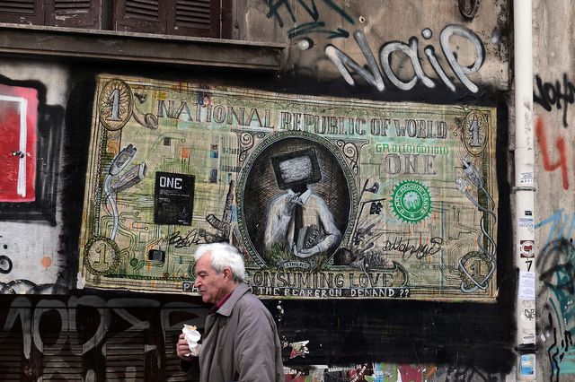 Мужчина проходит мимо граффити в центре Афин, на котором изображен новый министр финансов Греции Янис Варуфаки. Фото: AFP