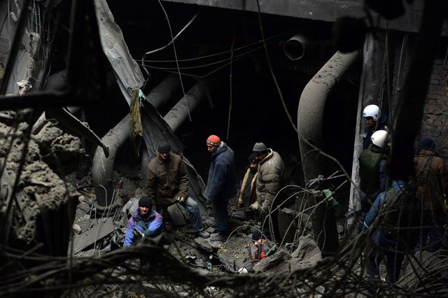 Пошук тіл загиблих "кіборгів" українськими полоненими військовослужбовцями в завалах будівель Донецького аеропорту. Фото: AFP