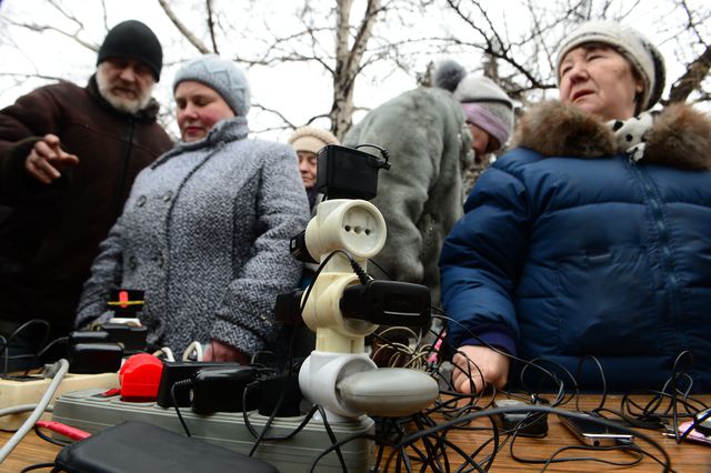 Местные жители в Дебальцево заряжают мобильные телефоны от переносных генраторов. Фото: AFP